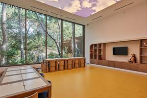 Ein Kinderzimmer im Maxx Royal Kemer Resort mit großen Fenstern und Panoramaaussicht auf einen Wald.