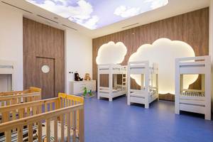 Kinderzimmer im Maxx Royal Kemer Resort mit mehreren Betten, Holzwänden und einer beleuchteten Wolkendecke.