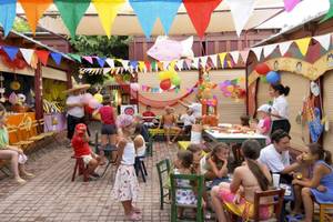 Kinderfest im Freien mit bunten Flaggen und Luftballons im Aquila Rithymna Beach Hotel.