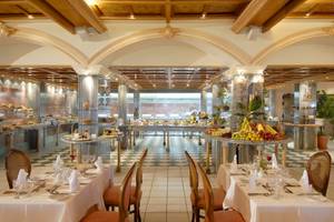 Frühstücksbuffet im Aquila Rithymna Beach Hotel mit verschiedenen Früchten und Speisen.