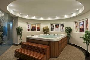 Jacuzzi im Hurghada Long Beach Resort mit Pflanzen und dekorativen Bildern an der Wand.