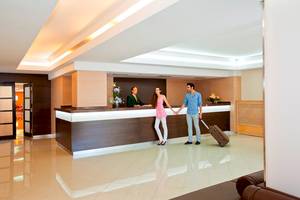 Paar im HSM Venus Playa Hotel-Lobby mit Gepäck und Rezeptionisten