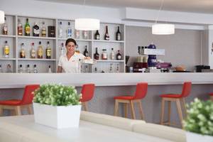 Eine Mitarbeiterin des HSM Venus Playa Hotels serviert Getränke an der Bar.
