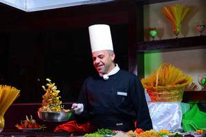 Koch beim Pickalbatros Jungle Aqua Park Resort serviert Gemüse auf einem Buffet.