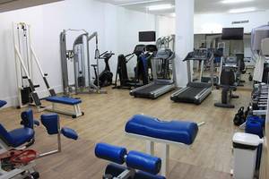 Fitnesscenter im Crystal Springs Beach Hotel mit Laufbändern, Hanteln und Trainingsgeräten.
