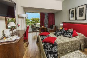Innenansicht eines Zimmers im Crystal Springs Beach Hotel mit einem großen Bett, Dekor und Möbeln.