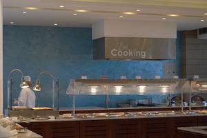 Live Cooking Bereich im Crystal Springs Beach Hotel mit Küchenutensilien und einem Koch.