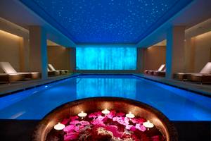 Innenpool des Astir Odysseus Kos Resort & Spa mit Sternenhimmel und Blumenkerzen