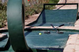 Minigolfkurs im Blue Bay Resort mit einem Ball und Schlägern auf dem Grün.