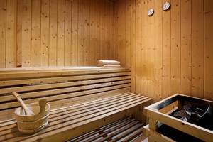 Saunaraum im Blue Bay Resort mit Holzbänken, Handtüchern und Holzeimern.