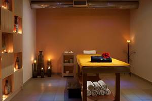 Spa-Behandlungsraum im Blue Bay Resort mit Massagetisch, Kerzen und Dekorationen.
