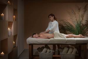 Massage im Blue Bay Resort mit Frau, die Rückenmassage gibt.