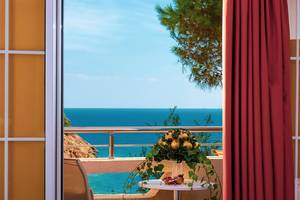 Balkonblick auf das Meer vom Blue Bay Resort mit Tisch und Blumen