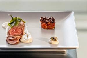 Gerichteter Teller mit Steak, Beilagen und Garnierungen.
