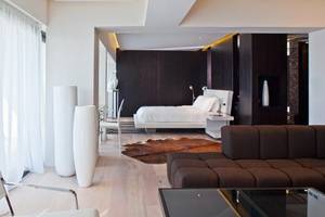 Schlafzimmer im Aqua Blu Boutique Hotel mit Bett, Couch, Teppich und Dekorationsgegenständen.