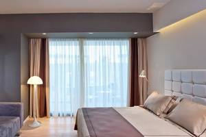 Hotelzimmer des Aqua Blu Boutique Hotel & Spa mit Fernseher, Lampe, Bett und Couch