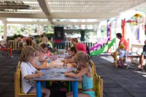 Kinder sitzen an einem Tisch im Freien und arbeiten an einem Puzzle im Royal Alhambra Palace.