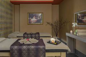 Spa-Behandlungsraum im Royal Alhambra Palace mit zwei Massagebetten, Kerzen und Kunstwerken an den Wänden.