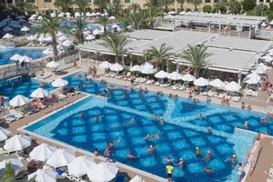 Luftaufnahme des Swimmingpool-Bereichs des Royal Alhambra Palace Hotels mit vielen Gästen und Sonnenschirmen.
