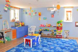 Kinderzimmer im Aktea Beach Village Hotel mit blauen Wandfarben, Spielzeug und Möbeln.