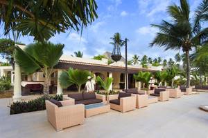 Loungebereich vor dem Bahari Zanzibar Hotel mit braunen Möbeln und Palmen.