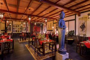 Innenansicht des Bahari Zanzibar Restaurants mit Buddha-Statue, gedeckten Tischen und traditioneller Dekoration.