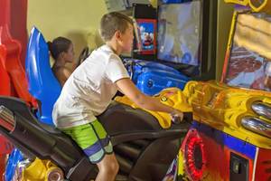 Ein Junge spielt einen Motorradsimulator im Royal Wings Hotel.