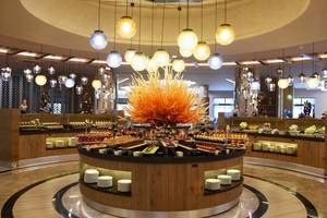 Buffettisch im Royal Wings Hotel mit einer Vielzahl von Speisen und vielen hängenden Lampen.