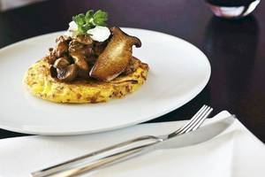 Ein Gericht mit Pilzen und Fleisch auf einem Teller serviert im Mövenpick Amsterdam City Centre.