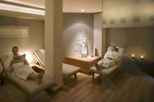 Ein Mann liest eine Zeitung auf einem Liegestuhl im Spa des Mövenpick Amsterdam City Centre