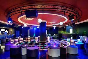 Disco-Raum im Crystal Sunset Luxury Resort & Spa mit bunten Lichtern und Möbeln.