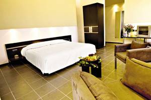 Innenansicht eines Hotelzimmers im Royal Decameron Tafoukt Beach Hotel mit Bett, Fernseher und Möbeln.