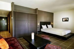 Zimmer im Royal Decameron Tafoukt Beach Hotel mit Bett, Sofa, Tisch und Dekoration.