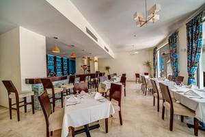 Innenansicht des Restaurants im Ancient Sands Golf Resort mit Tisch und Barbereich