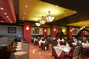 Innenansicht des Restaurants im Grand Palladium Jamaica R. & Spa mit roter und gelber Beleuchtung.