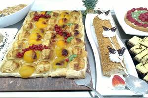 Buffet mit verschiedenen Obstgerichten und Desserts auf einem Tisch.