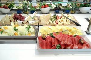 Buffet-Auswahl im Aparthotel Fontanellas Playa mit verschiedenen Käsesorten, Obst und Salaten.
