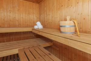 Innenansicht der Sauna im Aparthotel Fontanellas Playa mit Holzbänken und Handtuch