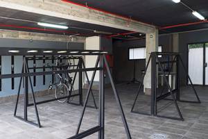 Fahrrad-Abstellplatz im Cosmopolitan Hotel mit Metallständern und einer leeren Wand im Hintergrund.