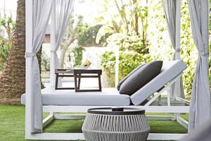 Lounge Stuhl mit Tisch und Getränken im Freien, bedeckt durch weiße Vorhänge, Cosmopolitan Hotel.