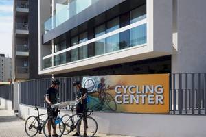 Zwei Radfahrer stehen vor dem Radverleih vor dem Cosmopolitan Hotel.
