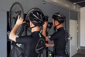 Zwei Männer stellen Fahrräder an einer Fahrradhalterung an.