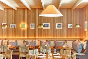 Innenansicht des Restaurants im 1 Hotel South Beach mit hölzernen Wänden, Sitzgelegenheiten und Tischen.