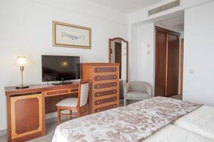 Innenansicht eines Hotelzimmers im Hipotels Flamenco mit Fernseher, Schreibtisch und Bett.