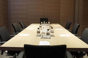 Ein Konferenzraum im Hotel Barcelona Catedral mit einer langen Tabelle und leeren Stühlen.