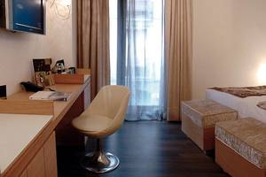 Hotelzimmer im Barcelona Catedral mit Schreibtisch, Stuhl, Betten und Fernseher.