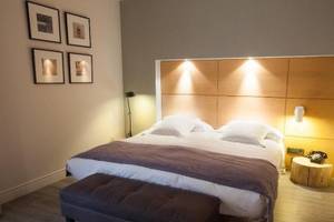 Schlafzimmer im Hotel Barcelona Catedral mit Doppelbett, Nachttisch und Bildern an der Wand.