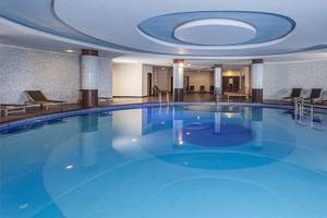 Innenpool des Sultan of Side Hotels mit blauem Wasser und Lounge-Liegen