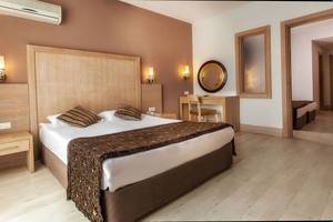 Hotelzimmer im Sultan of Side mit Kingsize-Bett, Dekor und Schreibtisch.