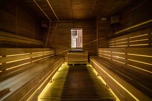 Innenansicht der Sauna im Sidemarin Kirman Premium mit Holzbänken und beleuchteten Wegen.